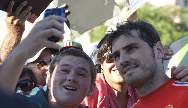 El portero del Real Madrid Iker Casillas se toma una foto con un aficionado.