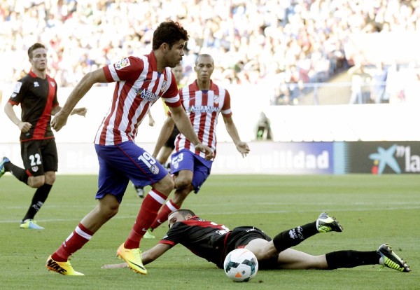 El delantero brasileño del Atlético de Madrid Diego Costa (i) disputa el balón con el defensa del Rayo Vallecano Nacho Martínez (d).