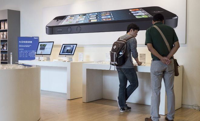 Clientes observan diversos dispositivos en oferta en una tienda Apple en Pekín (China).