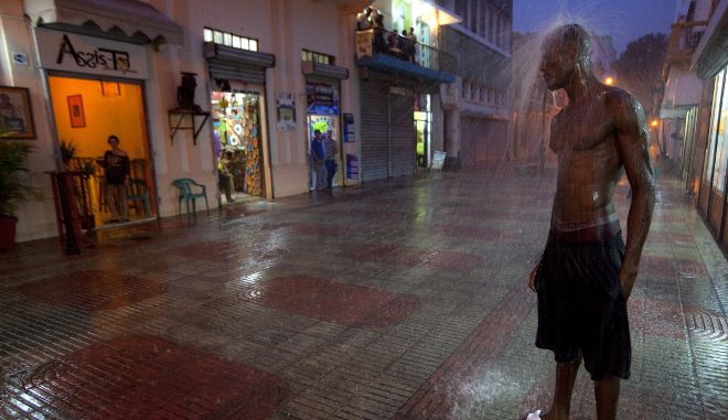 Un hombre permanece bajo la lluvia.
