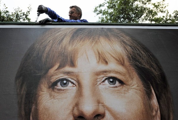 Un trabajador retira un cartel electoral con el rostro de la canciller alemana, Angela Merkel, en Itzehoe (Alemania).