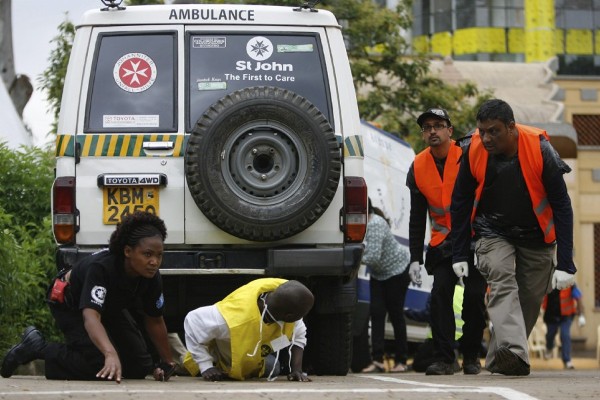 Oficiales y peatones corren en busca de refugio en los alrededores del Centro Comercial Westgate en Nairobi (Kenia) hoy, lunes 23 de septiembre de 2013.