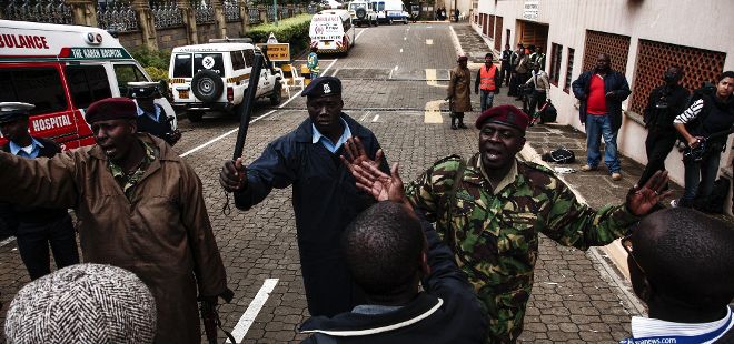 Varios policías y militares intentan alejar a los medios del centro comercial de Westgate, en Nairobi (Kenia).