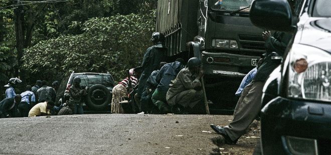 Numerosos soldados se cubren tras varios vehículos mientras aún continúan los disparos de distintas armas en el centro comercial de Westgate, en Nairobi (Kenia).