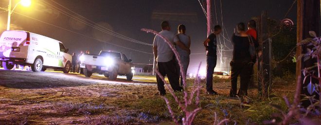 Un grupo de personas observa un cerco policial hoy, lunes 23 de septiembre de 2013, en la población de Loma Blanca en la fronteriza Ciudad Juárez (México).