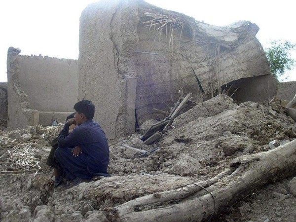 Varias personas permanecen junto a sus casas en ruinas tras el terremoto en Awaran (Pakistán) hoy, miércoles 25 de septiembre de 2013. 