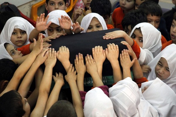 Niños palestinos tocan un pilar que simboliza la 
