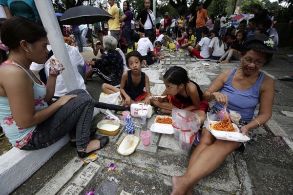 Una familia almuerza junto a la tumba de un ser querido para celebrar la festividad de Todos los Santos en el Cementerio Norte de Manila (Filipinas) hoy, viernes 01 de noviembre de 2013. 