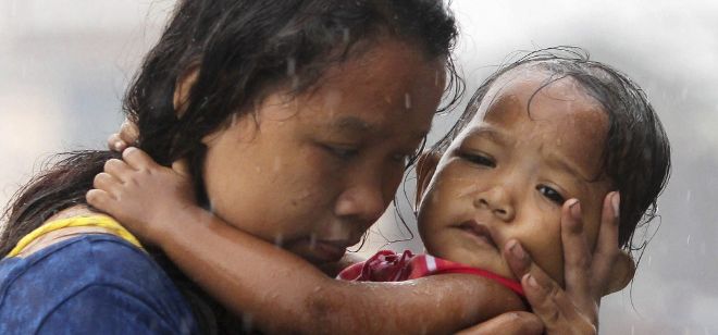 Una mujer filipina sostiene a un bebé, en Tacloban, en la provincia central de Leyte (Filipinas).