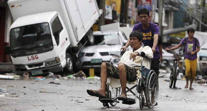 Varias personas recorren una calle en Tacloban, en la provincia central de Leyte (Filipinas),.