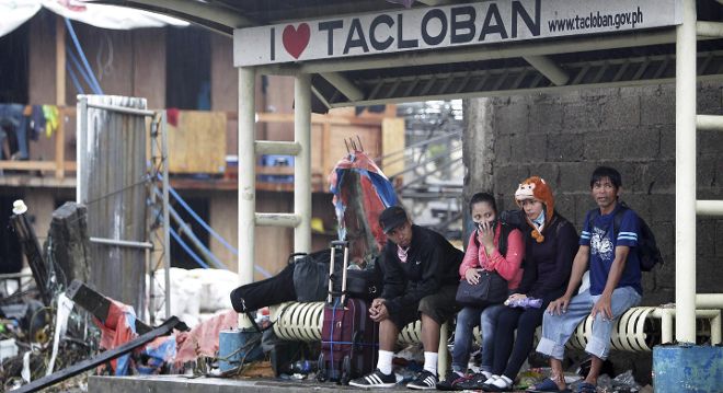 Varias personas esperan en una parada de autobús en Tacloban.