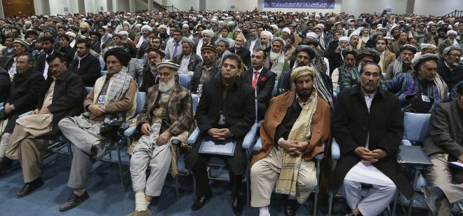 Delegados afganos escuchan el discurso del presidente afgano, Hamid Karzai.