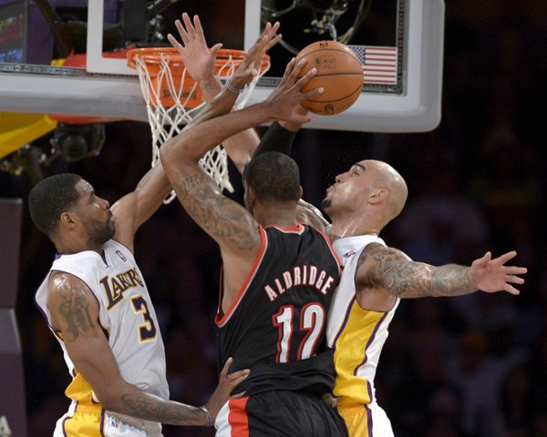 Portland Trail Blazers LeMarcus Aldridge (C) goes to the basket as Los Angeles Lakers Shawne Williams (L) and Robert Sacre (R) defend in second half NBA action in Los Angeles, California USA, 01 December 2013. The Trail Blazers beat the Lakers.