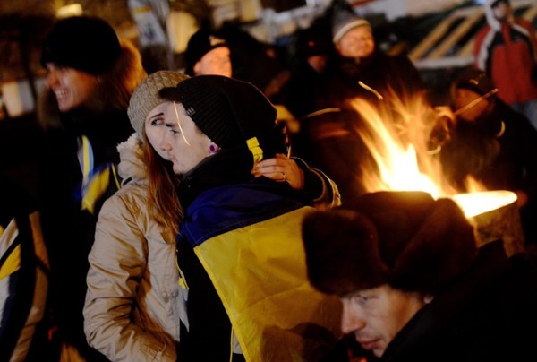 Manifestantes tratan de mantenerse calientes cerca a carpas este, miércoles 4 de diciembre de 2013, en la plaza de la Independencia en Kiev (Ucrania). Legisladores ucranianos discuten la posible dimisión del gobierno. Cientos de manifestantes trabajaron durante una segunda noche en la plaza principal plaza de Kiev, después de que cientos de ucranianos se reunieran para protestar masivamente y pedir la renuncia del presidente Viktor Yanukovych, por su decisión de suspender el acuerdo de asociación y comercio con la Unión Europea (UE).