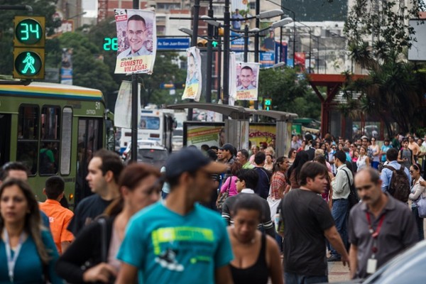 Deceneas de personas caminan por las calles de Cararas, donde se observan diferentes afiches de los candidatos a las elecciones municipales hoy, jueves 5 de diciembre de 2013. Los venezolanos comienzan la primera de las dos jornadas de reflexión antes de las elecciones municipales del 8 de diciembre en la que chavismo y oposición aspiran a 337 alcaldías del país.