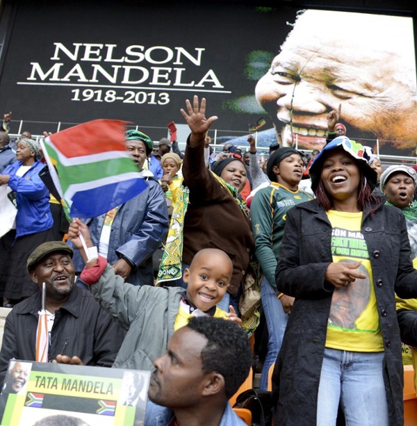 Varios asistentes aninan durante el servicio religioso oficial en memoria del fallecido expresidente sudafricano Nelson Mandela, en el estadio FNB de Soweto, Johannesburgo, Sudáfrica, el 10 de diciembre del 2013.