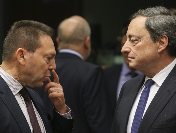 El ministro de Finanzas griego, Yannis Stournaras (i) conversa con el presidente del Banco Central Europeo (BCE), Mario Draghi (d) durante la reunión del Eurogrupo celebrada en la sede del Consejo Europea en Bruselas, Bélgica hoy 17 de diciembre de 2013.
