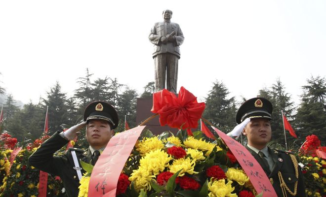 Dos policías chinos saludan frente a la estatua del fundador de la China socialista (1949), Mao Zedong, en Shaoshan, sur de China, el 25 de diciembre del 2013. China celebra mañana el 120 aniversario del nacimiento de Mao con una nueva generación de líderes políticos que ha pedido 