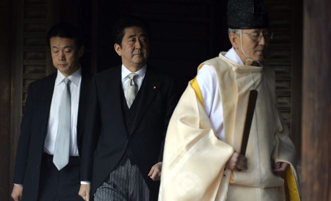 El primer ministro nipón, Shinzo Abe (centro), sigue a un sacerdote durante su visita al templo Yasunuki en Tokio (Japón) hoy, jueves 26 de diciembre de 2013. El Gobierno de EEUU mostró hoy su 