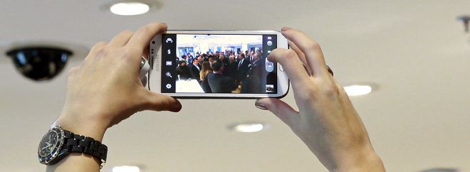 Una mujer realiza una fotografía con un móvil.