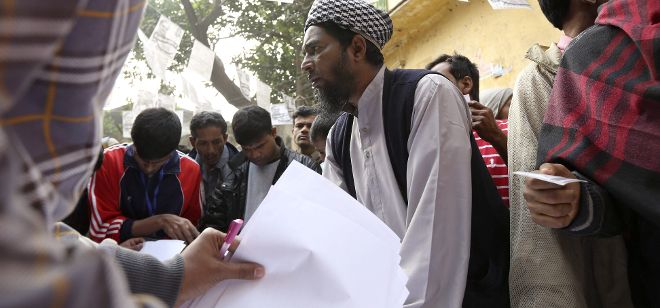 People ask a polling agent to find out their voting lists at a poll station during the tenth Bangladeshi national elections in Dhaka, Bangladesh, 05 January 2014. General elections were taking place in Bangladesh 05 January amid a boycott by the main opposition parties over suspicions of rigging by the ruling coalition of Prime Minister Sheikh Hasina.