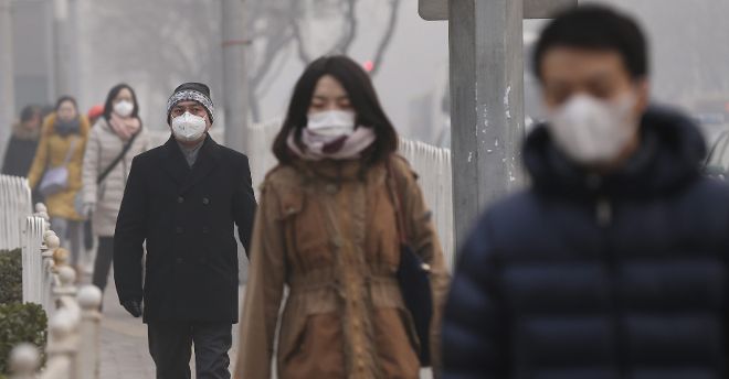 Ciudadanos chinos utilizan máscaras tapabocas en un día de neblina hoy, jueves 16 de enero de 2014, en Pekín (China). 