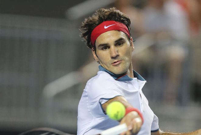 El tenista suizo Roger Federer devuelve la bola al esloveno Blaz Kavcic durante el partido que enfrentó a ambos en el Abierto de Australia celebrado en Melbourne (Australia) hoy, jueves 16 de enero de 2014.