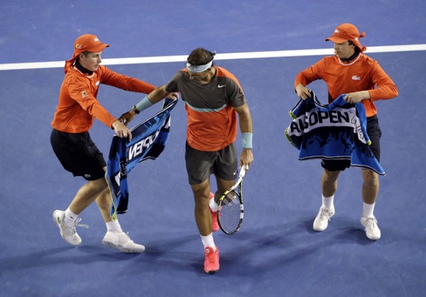 Los recogepelotas entregan toallas al tenista español Rafael Nadal durante el partido de semifinales del Abierto de Australia de tenis que le enfrentó al suizo Roger Federer en Melbourne (Australia) hoy, viernes 24 de enero de 2014.