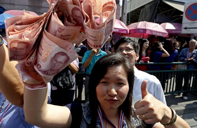 Una simpatizante del líder del movimiento gubernamental, Suthep Thaugsuban, muestra el dinero que está dispuesta a donar a Thaugsuban para que continúe con su campaña en Bangkok (Tailandia) hoy, viernes 31 de enero de 2014. Continúan las manifestaciones contra las elecciones generales del 2 de febrero en Tailandia.