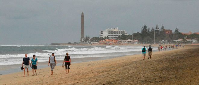 Vista de varias personas paseando por la playa de Maspalomas, en Gran Canaria.