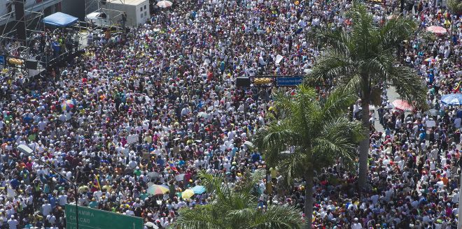 Un grupo de personas se reúne durante una nueva protesta de la oposición venezolana hoy, domingo 16 de febrero de 2014, en Caracas (Venezuela). Durante la tarde y noche de ayer se produjeron nuevamente enfrentamientos entre jóvenes de oposición y la policía antidisturbios en la capital venezolana. Varias sedes gubernamentales y entidades bancarias fueron atacadas con piedras durante los hechos.