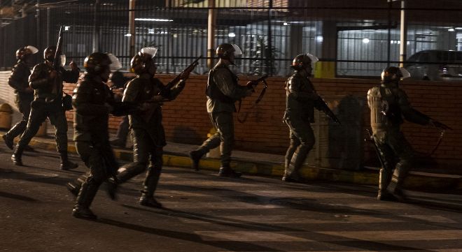 Miembros de la Guardia Nacional Bolivaraiana (GNB) permanecen alerta el lunes 17 de febrero de 2014, durante protestas registradas en el sector Los Ruices, cerca al canal de televisión estatal 
