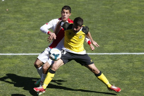 Coke protege el balón ante el centrocampista del Rayo Vallecano, Iago Falqué (detrás).
