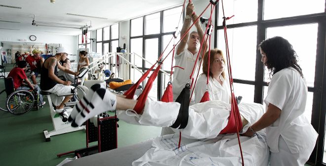Enfermeros en el gimnasio de rehabilitación del hospital Doctor Negrín, el que tiene las lislas más abultadas.