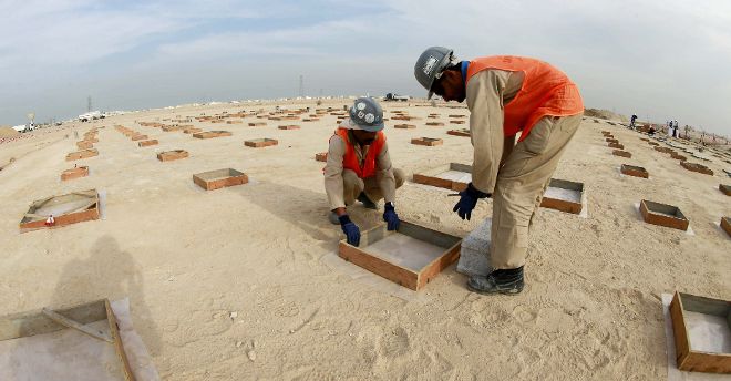 Fotografía facilitada por el Comité Supremo para la Entrega y el Legado, encargado de la construcción de los estadios que albergarán el Mundial de fútbol de Catar 2022, de dos de los 79 trabajadores que participan en la construcción del estadio Al Wakrah, con forma de 