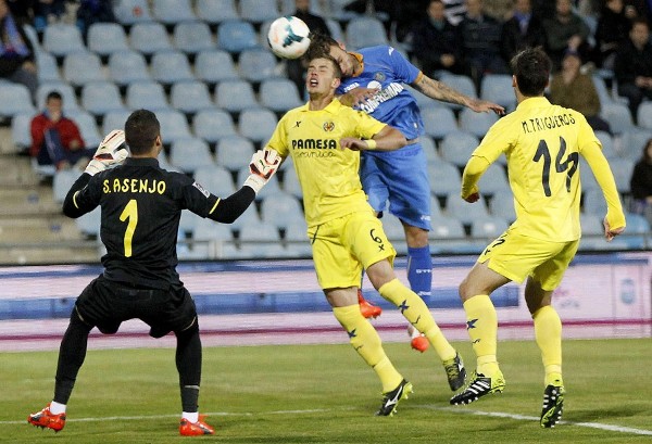 Aleksandar Pantic (c) y un jugador del Getafe, ante el portero del Villarreal Sergio Asenjo.