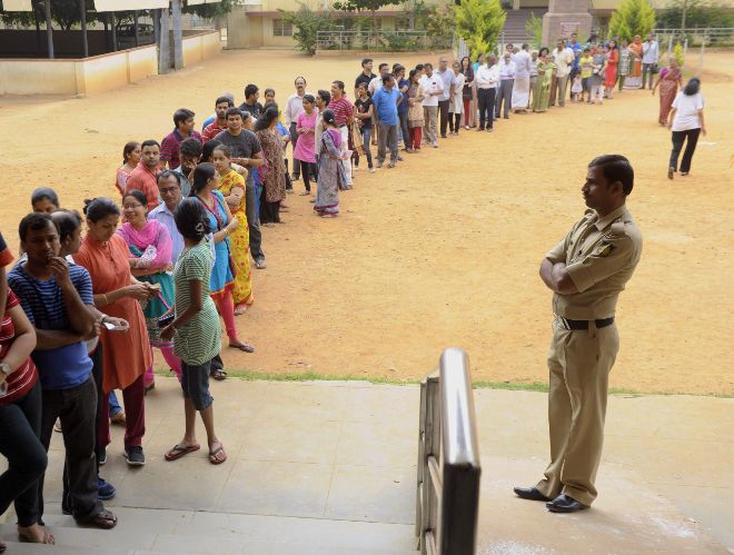 Votantes indios hacen fila para votar.