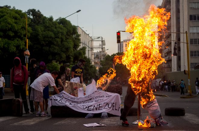 Un muñeco con el rostro del presidente de Venezuela, Nicolás Maduro, es quemado durante la popular fiesta de la Quema de Judas.