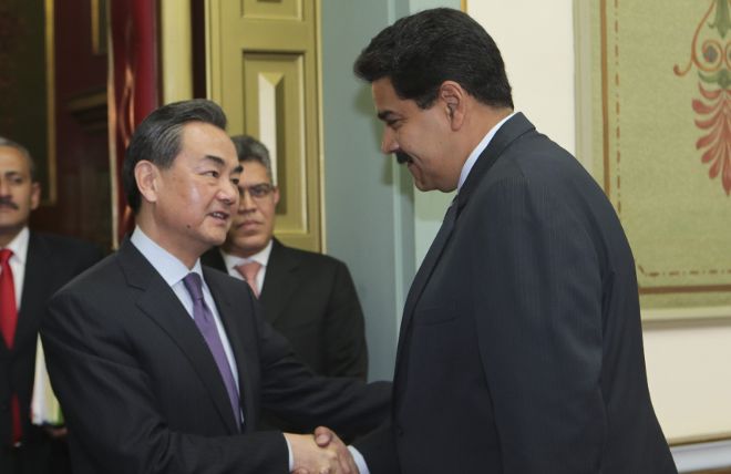 Nicolás Maduro (d) saludando al ministro de Relaciones Exteriores de China Wang Yi (i).
