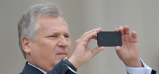 El expresidente polaco, Aleksander Kwasniewski, captura fotografías con su smartphone.