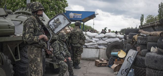 Varios soldados ucranianos vigilan un puesto de control establecido en la ciudad de Slaviansk, Ucrania hoy 5 de mayo de 2014. Las milicias prorrusas que defienden Slaviansk aseguran que diez personas, entre ellas civiles, murieron hoy en el asalto de las fuerzas ucranianas a un puesto de control de esta ciudad del sureste del país. 
