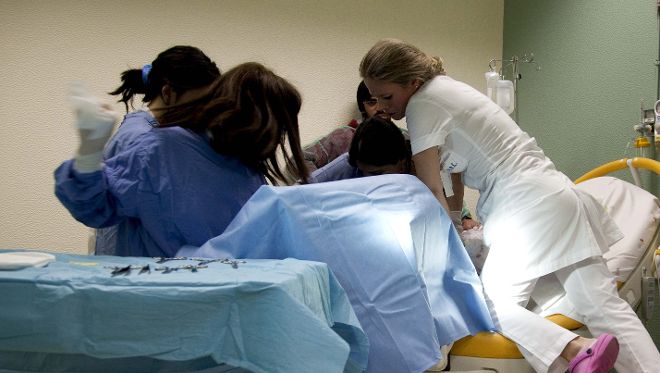 Doctores y enfermeras durante un trabajo de parto.