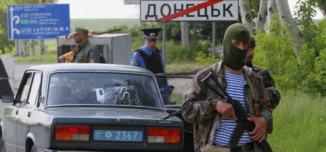 Unos militantes prorrusos hacen guardia en un puesto de control en Donetsk (Ucrania).