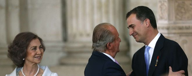 El Rey Juan Carlos besa al Príncipe de Asturias, Felipe de Borbón, junto a la Reina Sofía, esta tarde tras firmar la ley orgánica por la que se hace efectiva su abdicación.