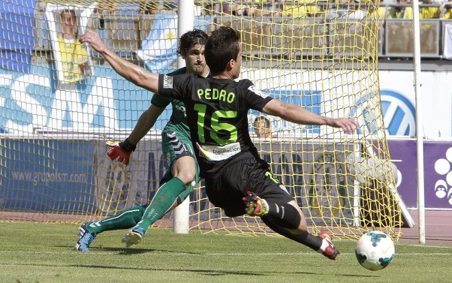 El centrocampista del Córdoba Pedro Sánchez (d) intenta superar al portero argentino de la Unión Deportiva Las Palmas Mariano Barbosa.