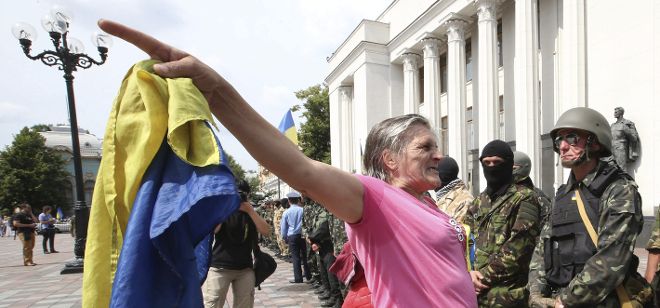 Una mujer habla con un grupo de paramilitares en Kiev.