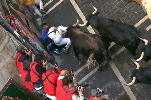 Mozos corren ante toros de la ganadería de Dolores Aguirre Ybarra en la calle Estafeta, durante el segundo encierro de los sanfermines 2014 por las calles de Pamplona, que ha sido rápido y limpio, sin ningún herido por asta.