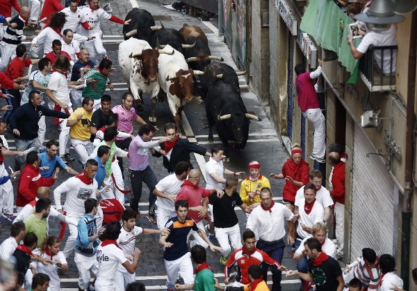 Los mozos corren ante los toros de la ganadería extremeña de Jandilla, ausentes desde el año 2010 de la feria del toro de Pamplona, que han protagonizado hoy el quinto encierro de los sanfermines 2014.