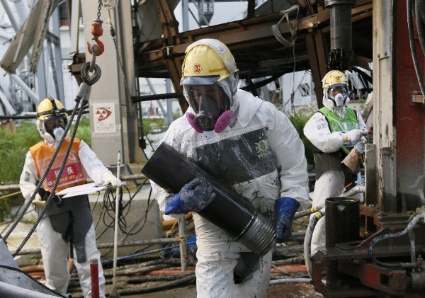 2014. Varios trabajadores preparan tuberías heladas para construir un muro de hielo para congelar el agua radiactiva en la planta nuclear Tokyo Electric Power (TEPCO), en Okuma, Fukushima, al nordeste de Tokio, Japón.