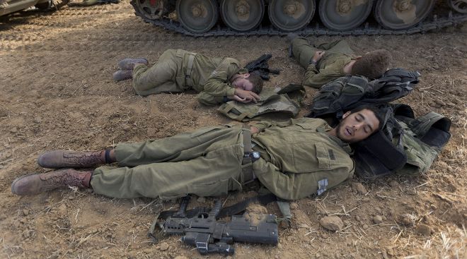 Soldados de infantería israelíes duermen cerca de Gaza.